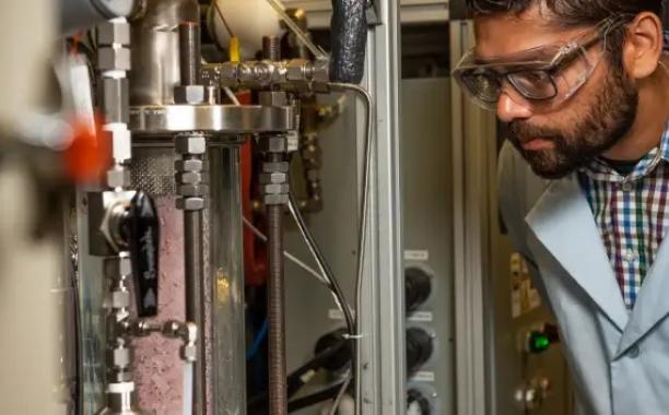 A scientist at Pacific Northwest National Laboratory looking at the carbon capture system technology. Photo courtesy Andrea Starr at Pacific Northwest National Lab. Photo courtesy Andrea Starr at Pacific Northwest National Lab.