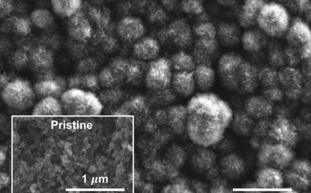 This scanning electron microscope image shows the carbon cathode of a carbon-dioxide-based battery made by MIT researchers, after the battery was discharged. It shows the buildup of carbon compounds on the surface, composed of carbonate material that could be derived from power plant emissions, compared to the original pristine surface (inset). Courtesy of the researchers