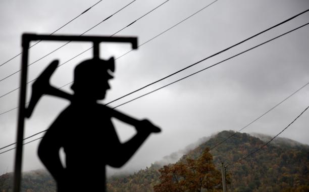 Fog hovers over a mountaintop as a cutout depicting a coal miner stands at a memorial to local miners killed on the job in Cumberland, Ky. (AP Photo/David Goldman, File)