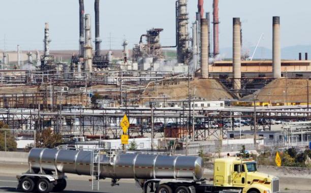 In this March 9, 2010 file photo, a tanker truck passes an oil refinery in Richmond, Calif. The Environmental Protection Agency (EPA) announced new rules Tuesday to reduce toxic air pollution from oil refineries by forcing operators to adopt new technology that better monitors and controls emissions. (AP Photo/Paul Sakuma, File) 